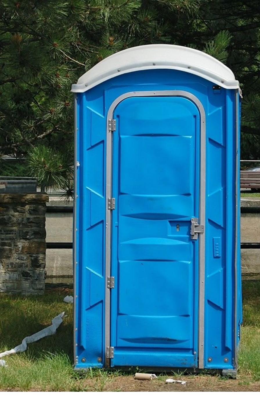 Construction crew taking a break near a portable toilet on site